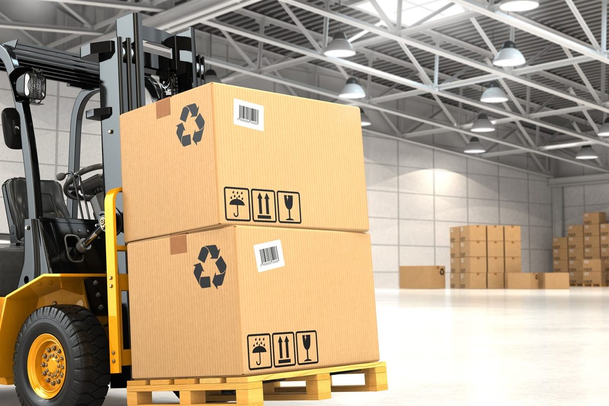 Forklift moving palletised cartons inside a distribution warehouse